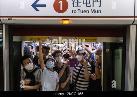 Passagiere, die im ersten Zug der Tuen Ma Line in Hongkong fahren, Sonntag, 26. Juni 2021. Heute hat die MTR-Ernte die Tune Ma-Linie vorgestellt, indem die bestehende West Rail- und die Ma-on-Shan-Linie bei Hung Hom über zwei neue Stationen nach Kwa Wan und Sung Wong Toi zusammengeführt werden. Die Tuen Ma-Linie verbindet die Ost- und West-New Territories. Mit einer Länge von 56 Kilometern und 27 Stationen ist sie heute die längste Strecke Hongkongs. (Foto von Vernon Yuen/NurPhoto) Stockfoto