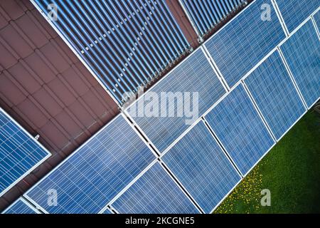 Photovoltaik-Paneele und Vakuum-Luft-Sonnenkollektoren für die Warmwasserbereitung und die Produktion von sauberem Strom auf dem Hausdach montiert. Produktion von Stockfoto