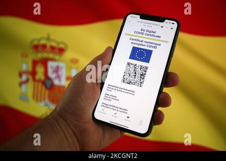 In dieser Abbildung am 1. Juli 2021 in Warschau, Polen, ist auf einem mobilen Gerät ein EU-COVID-Zertifikat mit einer spanischen Flagge im Hintergrund zu sehen. Das EU-COVID-Zertifikat, ein Dokument in digitaler oder analoger Form, das es vollständig geimpften Personen ermöglicht, in alle 27 EU-Mitgliedstaaten zu reisen, wird seit Juli 1 zur Verfügung gestellt. (Foto von STR/NurPhoto) Stockfoto