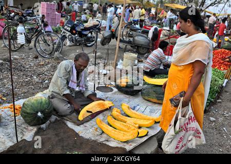 Auf dem größten Obst- und Gemüsemarkt in der indischen Stadt Nagpur, Maharashtra, Indien, schneidet man für einen Kunden einen großen Kürbis. (Foto von Creative Touch Imaging Ltd./NurPhoto) Stockfoto