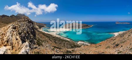 Panoramablick auf den Balos Beach, die unglaubliche Lagune mit dem türkisfarbenen exotischen und tropischen Wasser des Mittelmeers, befindet sich in der Region Chania auf der Insel Kreta. Balos ist einer der meistbesuchten Strände Kretas und beliebt bei Besuchern auf der ganzen Welt. Kristallklares Wasser, die Lagune, felsige steile Berge, eine Strandbar mit Sonnenschirmen und Schatten mit Getränken und eine Pirateninsel befinden sich in derselben Region, die mit einem 20-minütigen Trek oder Boot erreichbar ist. Griechenland versucht, seinen Tourismus anzukurbeln und Privilegien für Impfungen gegen die internationale Pandemie Covid-19 Coronavirus zu gewähren Stockfoto