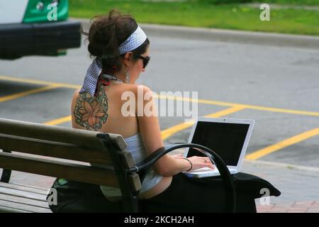 Mädchen mit einem großen Tattoo arbeitet am 14. Juli 2008 auf einem Laptop in Toronto, Ontario, Kanada. (Foto von Creative Touch Imaging Ltd./NurPhoto) Stockfoto