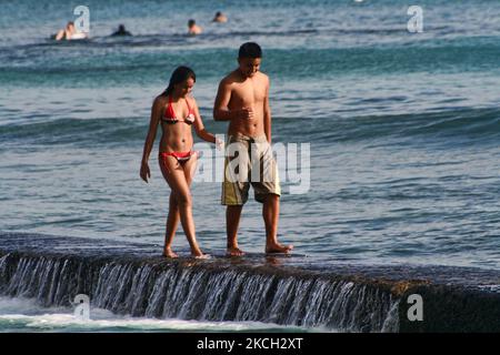 Paare auf ihren Flitterwochen spazieren am 20. Juli 2007 entlang eines Breakers im Meer am Waikiki Beach in Waikiki, Hawaii, USA. (Foto von Creative Touch Imaging Ltd./NurPhoto) Stockfoto