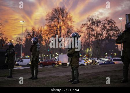 Chilenische Bereitschaftspolizei aus Carabineros de Chile, die direkt vor der auf dem Platz der würde installierten Polizei steht, um weitere Schäden an der Statue zu verhindern und die Gemeinde von Menschen zu vermeiden. Und mit einem schönen Sonnenuntergang. Eine Mauer, die zusammen mit der aktuellen Verfassung zu einem Symbol für den Abriss geworden ist. Mitten in der Demonstration und den Protesten auf der Plaza Dignidad (ehemals Plaza Italia), die die Freiheit der politischen Gefangenen der Mapuche, der Gefangenen der sozialen Revolte und der Subversiven forderten. Neben der Forderung nach Gerechtigkeit für die Opfer der Polizeirepression. Ende der ersten Woche der Verfassung Stockfoto