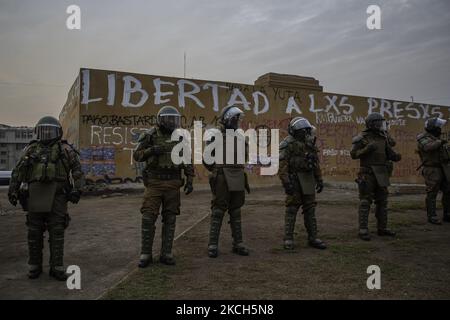 Chilenische Bereitschaftspolicen von Carabineros de Chile, die direkt vor der Wand stehen und den Satz -befreit die Gefangenen- an der Wand der Plaza Dignidad kratzen, um weitere Schäden an der Statue zu vermeiden und die Gemeinde von Menschen zu vermeiden. Eine Mauer, die zusammen mit der aktuellen Verfassung zu einem Symbol für den Abriss geworden ist. Mitten in der Demonstration und den Protesten auf der Plaza Dignidad (ehemals Plaza Italia), die die Freiheit der politischen Gefangenen der Mapuche, der Gefangenen der sozialen Revolte und der Subversiven forderten. Neben der Forderung nach Gerechtigkeit für die Opfer der Polizeirepression. Ende Th Stockfoto