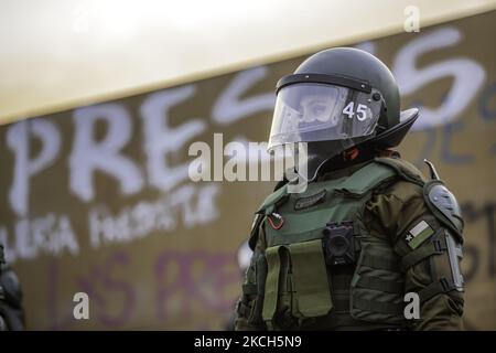 Eine Anti-Riot-Polizei von Carabineros de Chile, die direkt vor der Wand mit dem Wort „Gefangene“ steht, wurde auf der Plaza Dignidad installiert, um weitere Schäden an der Statue zu verhindern und die Gemeinde von Menschen zu vermeiden. Eine Mauer, die zusammen mit der aktuellen Verfassung zu einem Symbol für den Abriss geworden ist. Mitten in der Demonstration und den Protesten auf der Plaza Dignidad (ehemals Plaza Italia), die die Freiheit der politischen Gefangenen der Mapuche, der Gefangenen der sozialen Revolte und der Subversiven forderten. Neben der Forderung nach Gerechtigkeit für die Opfer der Polizeirepression. Ende der ersten Woche der Verfassung Stockfoto