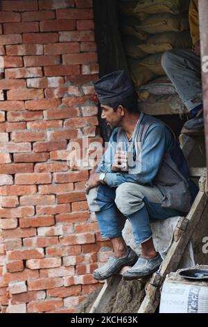 Nepalesischer Maurer mit traditioneller Mütze macht am 29. Mai 2010 auf einer Baustelle in Darjeeling, Westbengalen, Indien, eine Pause und trinkt eine Tasse Tee. (Foto von Creative Touch Imaging Ltd./NurPhoto) Stockfoto