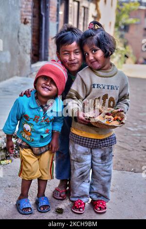 Kleine Kinder halten am 12. Dezember 2011 auf dem Weg zu einem Dorftempel mit heiligen Opfergaben im Dorf Sankhu in Kathmandu, Nepal, an, um für ein Foto zu posieren. Zwei der Kinder haben schwere Hautwunde im Gesicht. Eine gute Gesundheitsversorgung in ländlichen Gebieten Nepals ist selten und manchmal nicht vorhanden. (Foto von Creative Touch Imaging Ltd./NurPhoto) Stockfoto