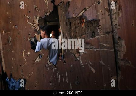 Kashmiri-Menschen bewerten das beschädigte Wohnhaus, in dem am 16. Juli 2021 bei einer Militäroperation in Srinagar, dem von Indien verwalteten Kaschmir, zwei Militante getötet wurden. Bei der Operation wurden zwei Kämpfer getötet und ein Wohnhaus beschädigt. (Foto von Muzamil Mattoo/NurPhoto) Stockfoto