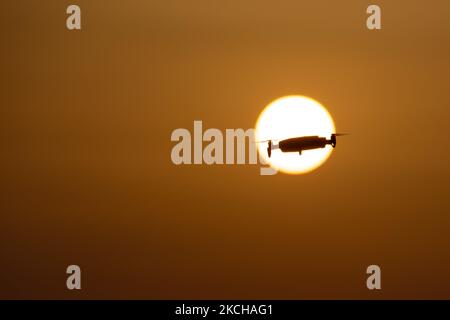 Eine Quadcopter-Drohne schwebt während eines Fluges vor der Sonne. Die fliegende Drohne wird als dunkle Silhouette gegen den spektakulären, farbenfrohen Sonnenuntergangshimmel und die Sonne gesehen, während die UAV in der Lage ist, Luftaufnahmen und Fotos über eine Fernbedienung aufzunehmen. Die spezifische Drohne ist eine DJI Mavic Air. Das unbemannte Luftfahrzeug ist bei Touristen beliebt, da die Technologie für jedermann in niedrigen Kosten zugänglich ist, aber auch viele professionelle Anwendungen hat Sani Beach Area, Chalkidiki, Griechenland am 15. Juli 2021 (Foto von Nicolas Economou/NurPhoto) Stockfoto