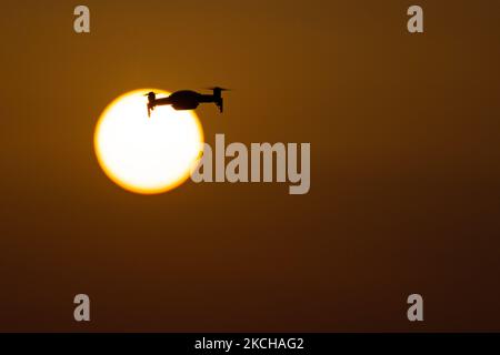 Eine Quadcopter-Drohne schwebt während eines Fluges vor der Sonne. Die fliegende Drohne wird als dunkle Silhouette gegen den spektakulären, farbenfrohen Sonnenuntergangshimmel und die Sonne gesehen, während die UAV in der Lage ist, Luftaufnahmen und Fotos über eine Fernbedienung aufzunehmen. Die spezifische Drohne ist eine DJI Mavic Air. Das unbemannte Luftfahrzeug ist bei Touristen beliebt, da die Technologie für jedermann in niedrigen Kosten zugänglich ist, aber auch viele professionelle Anwendungen hat Sani Beach Area, Chalkidiki, Griechenland am 15. Juli 2021 (Foto von Nicolas Economou/NurPhoto) Stockfoto