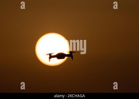 Eine Quadcopter-Drohne schwebt während eines Fluges vor der Sonne. Die fliegende Drohne wird als dunkle Silhouette gegen den spektakulären, farbenfrohen Sonnenuntergangshimmel und die Sonne gesehen, während die UAV in der Lage ist, Luftaufnahmen und Fotos über eine Fernbedienung aufzunehmen. Die spezifische Drohne ist eine DJI Mavic Air. Das unbemannte Luftfahrzeug ist bei Touristen beliebt, da die Technologie für jedermann in niedrigen Kosten zugänglich ist, aber auch viele professionelle Anwendungen hat Sani Beach Area, Chalkidiki, Griechenland am 15. Juli 2021 (Foto von Nicolas Economou/NurPhoto) Stockfoto