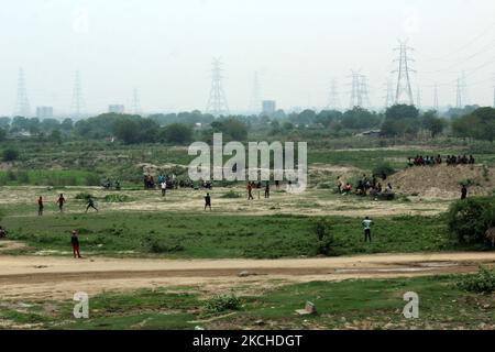 Junge Jungen spielen Cricket, da das Wetter vor der Regendusche in der Nähe des Flusses Yamuna in Neu-Delhi, Indien, am 18. Juli 2021 angenehm wird. (Foto von Mayank Makhija/NurPhoto) Stockfoto