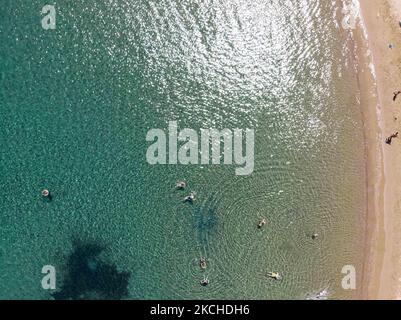 Panorama-Luftaufnahme von einer Drohne von Agios Giorgios oder Katigiorgis Village, Strand und Hafen in der Region Pelion in Griechenland mit Sonnenschein im Sommer. Katigiorgis ist ein malerisches Fischerdorf, 61km von der Stadt Volos und 3 Seemeilen von der Insel Skiathos entfernt und bietet eine einfache Möglichkeit für Touristen, die Inseln Skiathos und Sporaden oder Pilion mit der Fähre zu besuchen. Dieses Dorf ist klein, schön, friedlich und ruhig, ein abgeschiedenes Paradies im Mittelmeer, das seinen ursprünglichen Stil mit warmen Menschen behält, umgeben von üppigem Grün, Olivenhainen und niedrigen Hügeln, die nur ein paar Optionen für AC haben Stockfoto