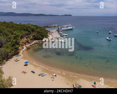 Panorama-Luftaufnahme von einer Drohne von Agios Giorgios oder Katigiorgis Village, Strand und Hafen in der Region Pelion in Griechenland mit Sonnenschein im Sommer. Katigiorgis ist ein malerisches Fischerdorf, 61km von der Stadt Volos und 3 Seemeilen von der Insel Skiathos entfernt und bietet eine einfache Möglichkeit für Touristen, die Inseln Skiathos und Sporaden oder Pilion mit der Fähre zu besuchen. Dieses Dorf ist klein, schön, friedlich und ruhig, ein abgeschiedenes Paradies im Mittelmeer, das seinen ursprünglichen Stil mit warmen Menschen behält, umgeben von üppigem Grün, Olivenhainen und niedrigen Hügeln, die nur ein paar Optionen für AC haben Stockfoto