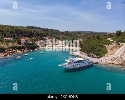 Panorama-Luftaufnahme von einer Drohne von Agios Giorgios oder Katigiorgis Village, Strand und Hafen in der Region Pelion in Griechenland mit Sonnenschein im Sommer. Katigiorgis ist ein malerisches Fischerdorf, 61km von der Stadt Volos und 3 Seemeilen von der Insel Skiathos entfernt und bietet eine einfache Möglichkeit für Touristen, die Inseln Skiathos und Sporaden oder Pilion mit der Fähre zu besuchen. Dieses Dorf ist klein, schön, friedlich und ruhig, ein abgeschiedenes Paradies im Mittelmeer, das seinen ursprünglichen Stil mit warmen Menschen behält, umgeben von üppigem Grün, Olivenhainen und niedrigen Hügeln, die nur ein paar Optionen für AC haben Stockfoto