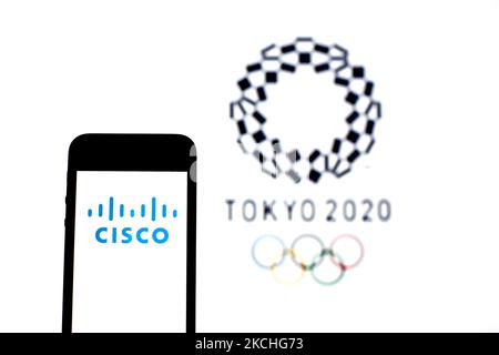 Auf dieser Abbildung ist ein Logo von Cisco Systems, Inc. Abgebildet, das auf einem Smartphone mit einem Logo der Olympischen Spiele 2020 in Tokio im Hintergrund zu sehen ist. (Foto von DAX Images/NurPhoto) Stockfoto