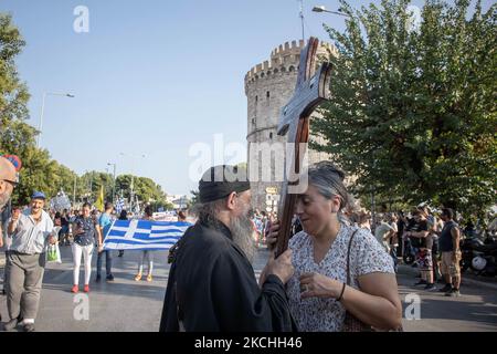 Ein Priester hält ein Kreuz während einer Demonstration gegen den obligatorischen Impfstoff, der am Mittwoch, den 21. Juli 2021 in Thessaloniki und Athen in Griechenland stattfand. Eine Woche nach dem massiven Protest gegen die obligatorische Impfung wird die Anti-Vaxx-Kampagne fortgesetzt, und eine große Gruppe protestiert auf den Straßen der Stadt Thessaloniki. Der Protest wurde über die sozialen Medien von Anti-Impfgläubigen organisiert. Nach Angaben der Gruppe nahmen mehr als 40,000 Personen Teil, während die Polizei inoffiziell leicht etwa 15,000 Personen an der Demonstration schätzte. Während die griechische Regierung vorübergeht Stockfoto