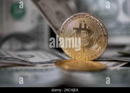 Bitcoin goldene physische Münze Illustration auf US-Dollar-Banknoten. Visuelle Darstellungen der digitalen Kryptowährung Bitcoin mit dem USD-Schein. Bitcoin mit dem Symbol BTC ist XBT eine beliebte digitale Währung, die Wachstum zeigte und weit verbreitet ist und von Banken, Märkten und anderen Dienstleistungen und Geschäften als Zahlungsmittel akzeptiert wird. Der heutige Wechselkurs für 1 Bitcoin Blockchain beträgt 32,287 US-Dollar. Der Wert des Kryptowährungs-Bitcoins ist auf ein Rekordhoch im Jahr 2021 angestiegen und erreichte laut den amerikanischen Finanzmedien $63.000. Thessaloniki, Griechenland am 23. Juli 2021 (Foto von Nicolas E Stockfoto