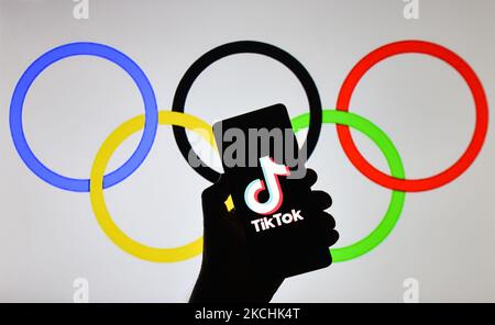 Ein illustratives Bild des Tik Tok-Logos, das auf einem Mobiltelefon vor den Olympischen Ringen auf einem Bildschirm angezeigt wird. Am Samstag, den 24. Juli 2021, in Krakau, Polen. (Foto von Artur Widak/NurPhoto) Stockfoto