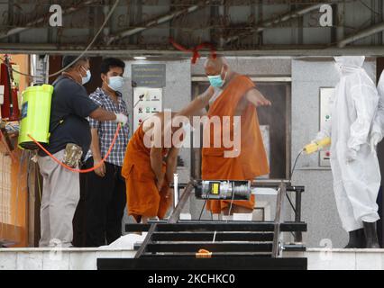 Am 24. Juli 2021 sprüht ein Mann Desinfektionsmittel an einen buddhistischen Mönch in einem Krematorium während einer Trauerfeier im Wat Bang Muang, in der Provinz Nonthaburi, am Stadtrand von Bangkok. Die Thailands-Tageszeitung Covid-19 stieg am Samstag um 14.260, was die Gesamtzahl auf 481.967 mit 119 Todesfällen erhöhte. (Foto von Chaiwat Subprasom/NurPhoto) (Foto von Chaiwat Subprasom/NurPhoto) Stockfoto