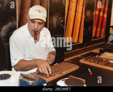 Arbeiter raucht eine große Zigarre, während er frisch gerollte Zigarren wiegt und überprüft sie am 19. Dezember 2012 in der Cigar-Fabrik von Laflor Dominicana in La Romana, Dominikanische Republik, auf ihre Qualität. (Foto von Creative Touch Imaging Ltd./NurPhoto) Stockfoto