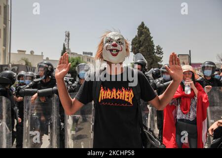 Ein junger Protestler mit Maskengesten vor Polizeimitgliedern während einer Demonstration in der Nähe des tunesischen parlaments in der Stadt Bardo in der Hauptstadt Tunis, Tunesien, am 25. Juli 2021, um den Sturz des Regimes zu fordern, Die Auflösung des parlaments und die Forderung nach einem Abtritt der Regierung von Hichem Mechichi. (Foto von Chedly Ben Ibrahim/NurPhoto) Stockfoto