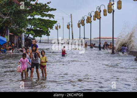 Kinder waten am 26. Juli 2021 in der Nähe der Küste der verschmutzten Bucht von Manila im Bezirk Tondo, Manila City, Philippinen, durch das Flutwasser. Der Taifun in-fa verließ im vergangenen Juli 23 das Verantwortungsgebiet der Philippinen, verursachte aber in mehreren Teilen des Landes andauernden Regen und Überschwemmungen, da er den Südwestmonsun verstärkte. (Foto von George Calvelo/NurPhoto) Stockfoto