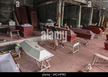 Indonesische Zimmermannsarbeiter bereiten Särge für COVID-19-Opfer vor, bevor sie am 26. Juli 2021 in Deli Serdang, Indonesien, an Krankenhäuser verteilt werden. Indonesien, das viertbevölkerungsreichste Land der Welt, hat die Gültigkeitsdauer seines Straßenzustands verlängert, indem es Notbeschränkungen für 15 Standorte außerhalb von Java und Bali auferlegt hat, um den jüngsten Anstieg von COVID-19 zu bändigen. Das Land war während der Pandemie am schlimmsten betroffen, die Gesamtzahl der Infektionsfälle lag bei über drei Millionen, es gibt derzeit 569.901 aktive Fälle und 1.487 Todesfälle, die am Montag verzeichnet wurden, was es zum Epizentrum von t macht Stockfoto