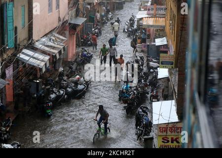 Pendler waten am 26. Juli 2021 während des Regens in Jaipur, Rajasthan, Indien, durch eine wasserdurchströmte Straße. (Foto von Vishal Bhatnagar/NurPhoto) Stockfoto