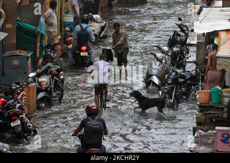 Pendler waten am 26. Juli 2021 während des Regens in Jaipur, Rajasthan, Indien, durch eine wasserdurchströmte Straße. (Foto von Vishal Bhatnagar/NurPhoto) Stockfoto