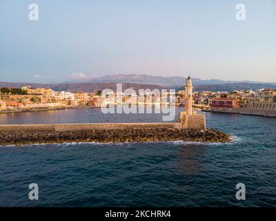 Panorama-Luftaufnahme einer Drohne während der magischen Stunde nach dem Sonnenuntergang des schönen alten venezianischen Hafens von Chania Stadt mit den Lichtern beleuchtet der erstaunliche Leuchtturm, Moschee, venezianischen Werften und alten den Denkmälern und Wahrzeichen in der Nähe des Hafens und des Meeres. Griechenland versucht, seinen Tourismus anzukurbeln und Impfprivilegien gegen die Coronavirus-Pandemie Covid-19, internationale Touristen und Einheimische zu gewähren, da das Land trotz der in Bezug auf die steigende Anzahl von Fällen mit der Covid-19 Coronavirus Delta Mutation Variante stark von der Reise- und Tourismusindustrie abhängig ist. Chania, Cre Stockfoto