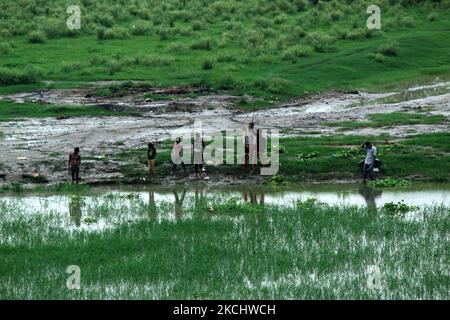 Die Menschen fischen in einem Teich in der Nähe des Yamuna-Flusses, während es während des Monsuns in Neu-Delhi, Indien, am 28. Juli 2021 regnet. (Foto von Mayank Makhija/NurPhoto) Stockfoto