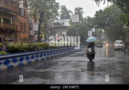 Ein Paar trägt bei starken Regenfällen in Kalkutta, Indien, am 28. Juli 2021 einen Regenschirm auf seinem Fahrrad. (Foto von Indranil Aditya/NurPhoto) Stockfoto