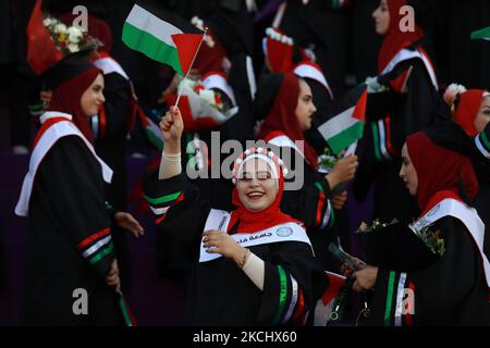 Palästinensische Studentinnen nehmen am 28. Juli 2021 an ihrer Abschlussfeier an der palästinensischen Universität in der Stadt Al-Zahra im Zentrum des Gazastreifens Teil. (Foto von Majdi Fathi/NurPhoto) Stockfoto