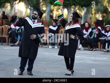 Palästinensische Studentinnen nehmen am 28. Juli 2021 an ihrer Abschlussfeier an der palästinensischen Universität in der Stadt Al-Zahra im Zentrum des Gazastreifens Teil. (Foto von Majdi Fathi/NurPhoto) Stockfoto