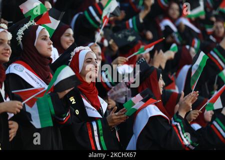 Palästinensische Studentinnen nehmen am 28. Juli 2021 an ihrer Abschlussfeier an der palästinensischen Universität in der Stadt Al-Zahra im Zentrum des Gazastreifens Teil. (Foto von Majdi Fathi/NurPhoto) Stockfoto