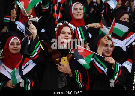 Palästinensische Studentinnen nehmen am 28. Juli 2021 an ihrer Abschlussfeier an der palästinensischen Universität in der Stadt Al-Zahra im Zentrum des Gazastreifens Teil. (Foto von Majdi Fathi/NurPhoto) Stockfoto