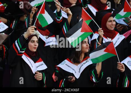 Palästinensische Studentinnen nehmen am 28. Juli 2021 an ihrer Abschlussfeier an der palästinensischen Universität in der Stadt Al-Zahra im Zentrum des Gazastreifens Teil. (Foto von Majdi Fathi/NurPhoto) Stockfoto