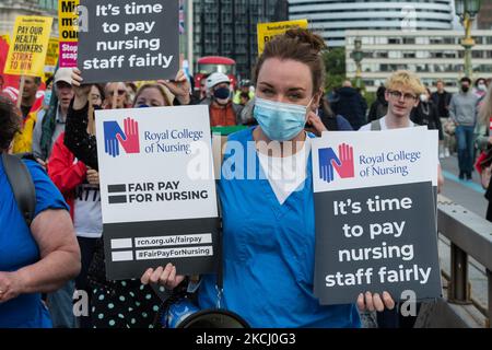 LONDON, VEREINIGTES KÖNIGREICH - 30. JULI 2021: NHS-Mitarbeiter und ihre Unterstützer marschieren am 30. Juli 2021 in London, England, vom St. Thomas' Hospital zur Downing Street, während einer Protestaktion, die eine faire Lohnerhöhung für Gesundheitshelfer forderte. Die Regierung hat eine Gehaltserhöhung von 3 % für die NHS-Mitarbeiter in England und Wales gemäß den Empfehlungen des NHS Pay Review Body angekündigt. Die Aktivisten argumentieren jedoch, dass das Angebot die Inflationsrate nicht erfüllt und unterschätzt die Beschäftigten im Gesundheitswesen, die während der Coronavirus-Pandemie einen beispiellosen Druck erlebten. (Foto von Wiktor Szymanowicz/NurPhoto) Stockfoto