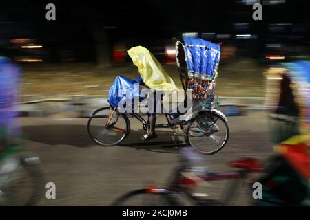 Ein Rikscha-Abzieher bedeckte ihn am 30. Juli 2021 bei Regenfällen in Dhaka, Bangladesch, mit Polyethylen. (Foto von Syed Mahamudur Rahman/NurPhoto) Stockfoto