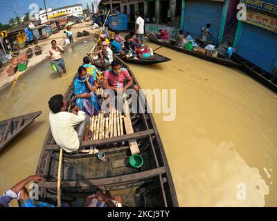 Indische Überschwemmungsopfer auf einem Boot machen sich am 5. August 2021 auf den Weg durch die Überschwemmungsgewässer, nachdem sie Hilfsmaterialien im Ghatal-Gebiet des Bezirks Paschim Medinipur, etwa 112 km von Kalkutta entfernt, gesammelt haben. (Foto von Debajyoti Chakraborty/NurPhoto) Stockfoto