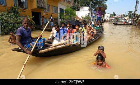 Eine Frau mit ihren Kindern unter dem Hochwasser und Flutopfer auf einem Boot machen sich ihren Weg durch das Flutwasser, nachdem sie am 5. August 2021 im Ghatal-Gebiet des Bezirks Paschim Medinipur, etwa 112 km von Kalkutta entfernt, Hilfsmaterial gesammelt haben. (Foto von Debajyoti Chakraborty/NurPhoto) Stockfoto