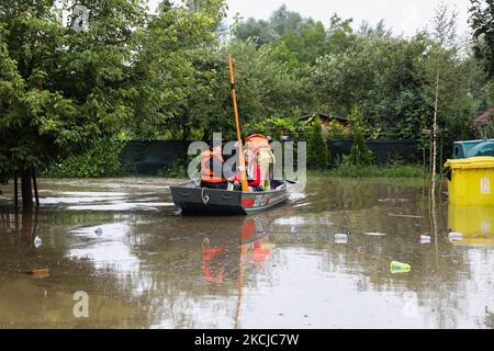 Feuerwehrleute schwimmen auf einem Boot, nachdem am 6.. August 2021 Straßen und Haushalte in den Gebieten des Bierzanow-Bezirks in Krakau, Polen, mit heftigen Regenschauern überflutet wurden. (Foto von Beata Zawrzel/NurPhoto) Stockfoto