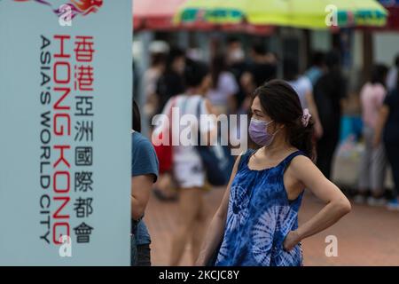 Eine Dame ist am 7. August 2021 in Hongkong, China, in Zentral-Hongkong vor einer Anzeige für „Hongkong, Asiens Weltstadt“ zu sehen. (Foto von Marc Fernandes/NurPhoto) Stockfoto