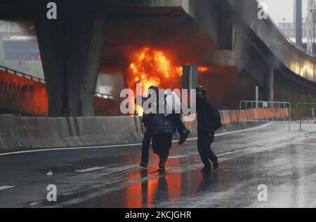 Ein verletzte Protestler wird von seinem Freund nach Zusammenstößen mit Bereitschaftspolizisten während der Demonstration an der Kreuzung DIN Daeng in Bangko kon am 11. August 2021 mitgebracht. Die Polizei feuerte Tränengas und Gummigeschosse, um am Mittwoch einen weiteren regierungsfeindlichen Protest in Bangkok zu zerstreuen. Die von der Tha Lu Fah Gruppe organisierte Demonstration begann um 3pm Uhr am Siegessäule. Hunderte von Demonstranten warfen Farbe auf eine Reihe von Bereitschaftspolizisten, die sie konfrontierten, als sie versuchten, zum Wohnsitz des Premierministers Prayut Chan-o-cha beim Infanterie-Regiment 1. in der Vibhavadi Rangsit Road zu marschieren. (Foto von Chaiwat Subprasom Stockfoto