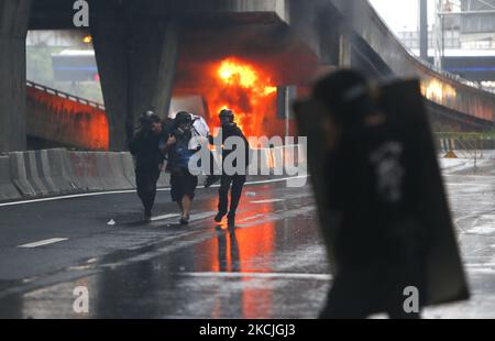 Ein verletzte Protestler wird von seinem Freund nach Zusammenstößen mit Bereitschaftspolizisten während der Demonstration am DIN Daeng Kreuzung in Bangkok am 11. August 2021 mitgebracht. Die Polizei feuerte Tränengas und Gummigeschosse, um am Mittwoch einen weiteren regierungsfeindlichen Protest in Bangkok zu zerstreuen. Die von der Tha Lu Fah Gruppe organisierte Demonstration begann um 3pm Uhr am Siegessäule. Hunderte von Demonstranten warfen Farbe auf eine Reihe von Bereitschaftspolizisten, die sie konfrontierten, als sie versuchten, zum Wohnsitz des Premierministers Prayut Chan-o-cha beim Infanterie-Regiment 1. in der Vibhavadi Rangsit Road zu marschieren. (Foto von Chaiwat Subprasom Stockfoto