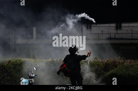 Während der Demonstration in Bangkok am 13. August 2021 trifft ein Protestler mit einem Tennisschläger auf eine Tränengasgranate zurück, um Polizisten zu entführen. Die Polizei in Bangkok feuerte Gummigeschosse und Tränengas auf prodemokratische Demonstranten, die den Premierminister Prayut Chan-o-cha zum Abtritt forderten und die Regierung für ihr grobes Missmanagement der Covid-19-Pandemie zur Verantwortung ziehen sollten. (Foto von Chaiwat Subprasom/NurPhoto) (Foto von Chaiwat Subprasom/NurPhoto) Stockfoto