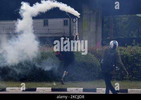 Während der Demonstration in Bangkok am 13. August 2021 trifft ein Protestler mit einem Tennisschläger auf eine Tränengasgranate zurück, um Polizisten zu entführen. Die Polizei in Bangkok feuerte Gummigeschosse und Tränengas auf prodemokratische Demonstranten, die den Premierminister Prayut Chan-o-cha zum Abtritt forderten und die Regierung für ihr grobes Missmanagement der Covid-19-Pandemie zur Verantwortung ziehen sollten. (Foto von Chaiwat Subprasom/NurPhoto) (Foto von Chaiwat Subprasom/NurPhoto) Stockfoto