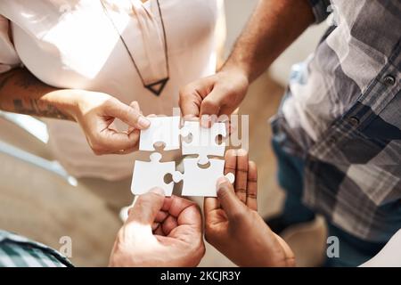 Teamarbeit kümmert sich um die Problemlösung. Eine Gruppe von Kreativen verbindet Teile eines Puzzles. Stockfoto